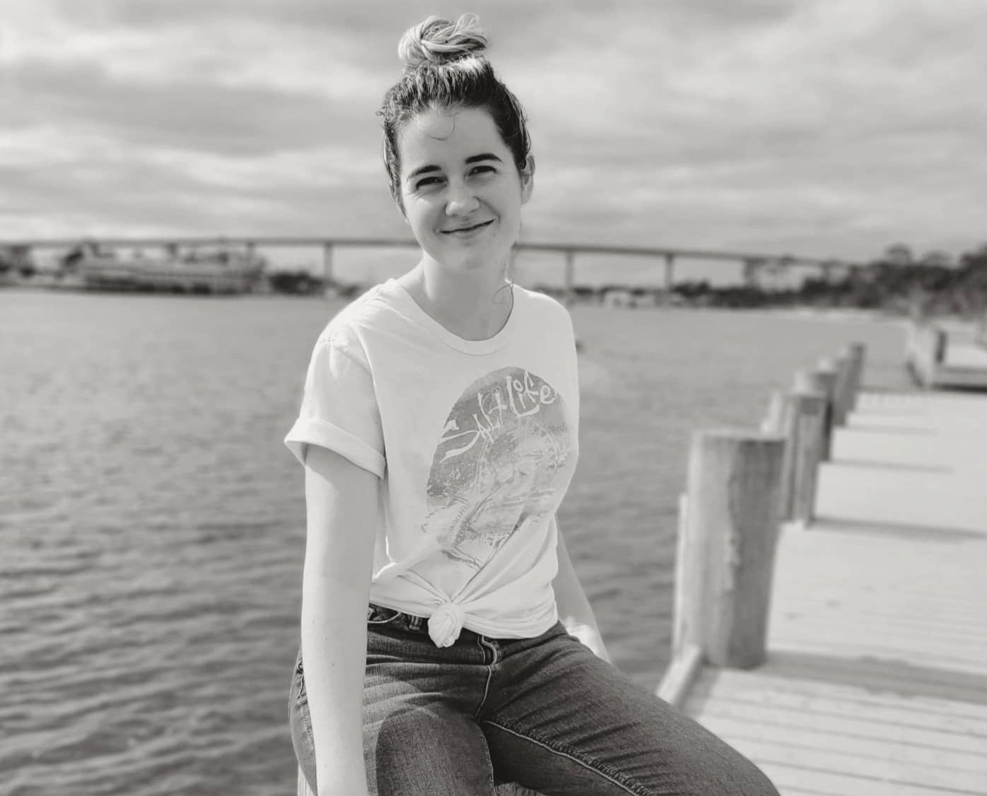 Woman Sitting On A Dock And Smiling