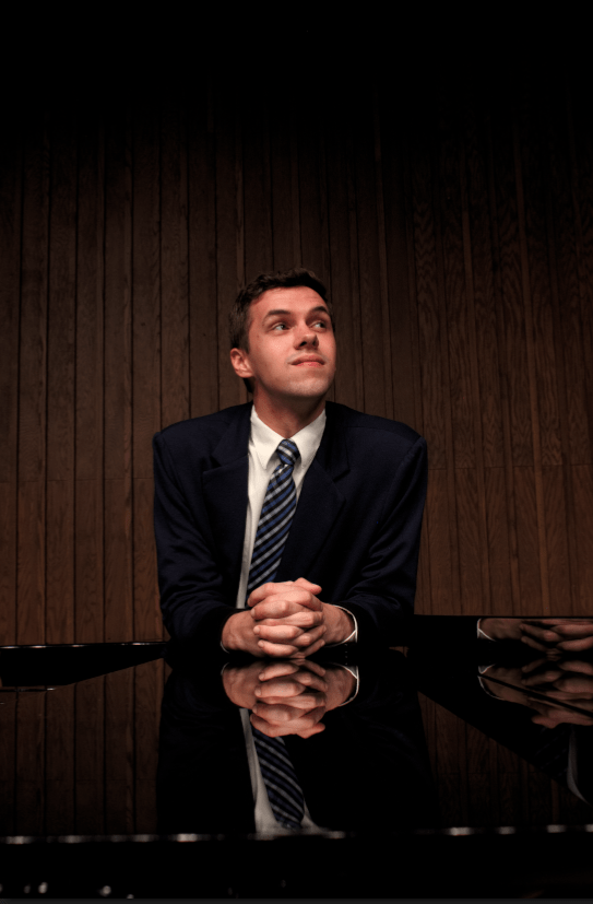 Man Leaning With Crossed Hands On A Piano